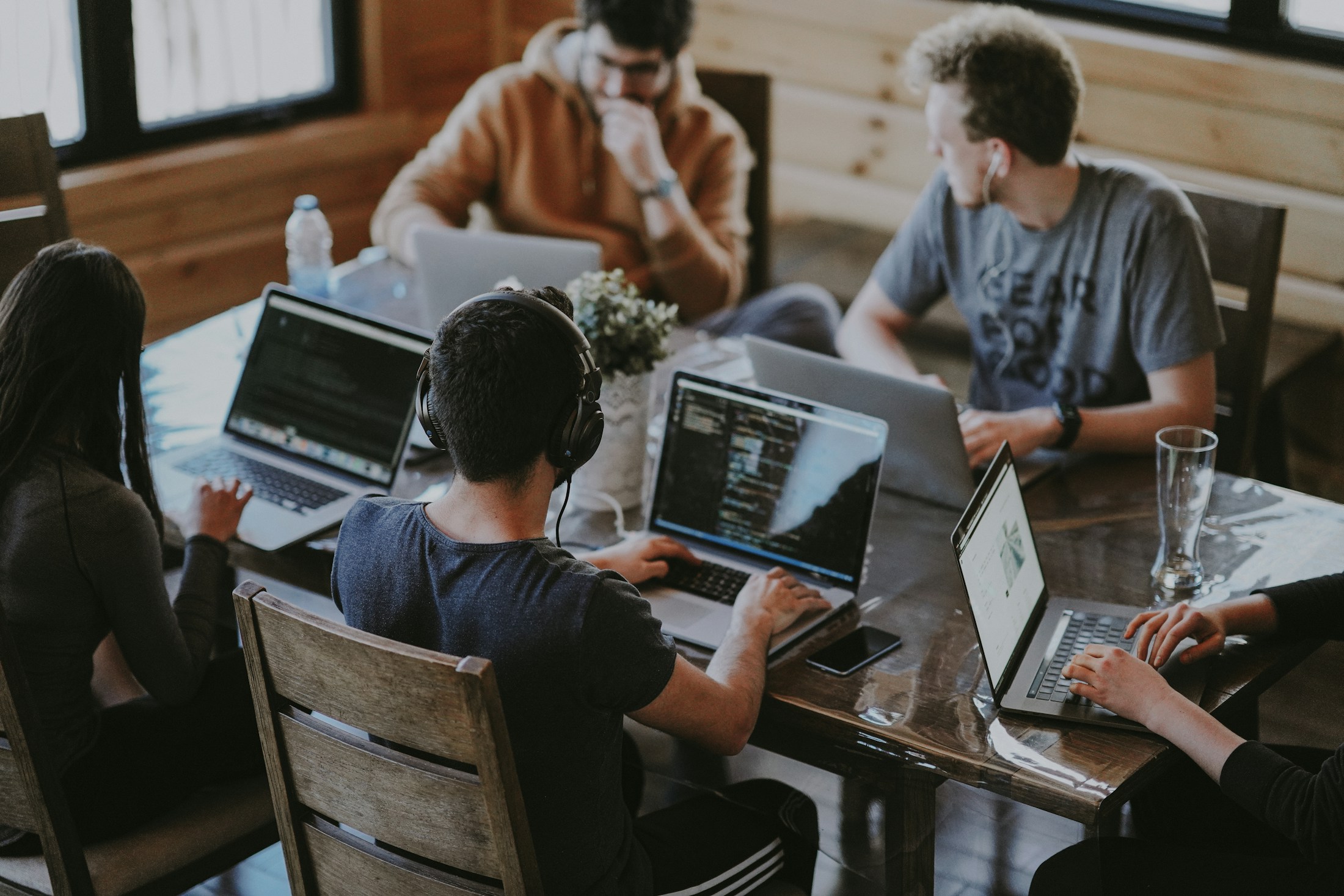 Colleagues collaborating around computers in a shared workspace.