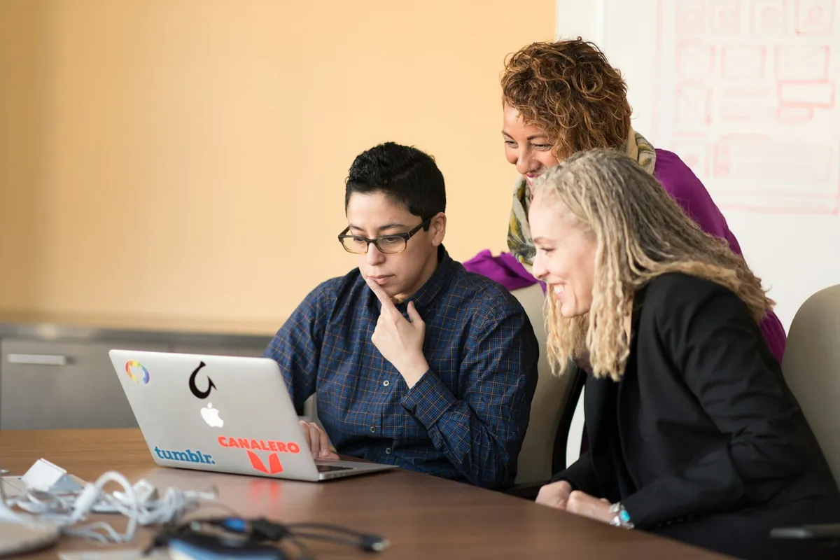 Three colleagues trying a digital tool together at a laptop