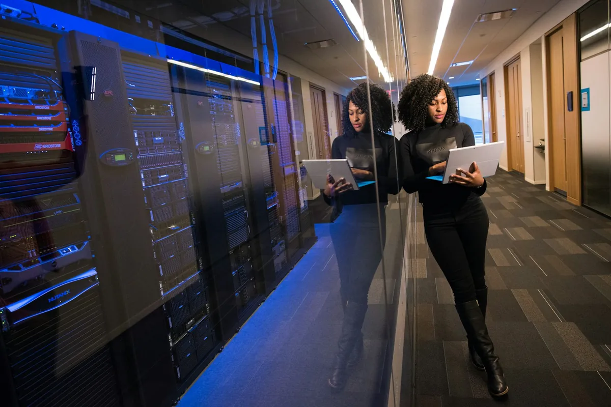 Technology specialist using a laptop beside enterprise systems