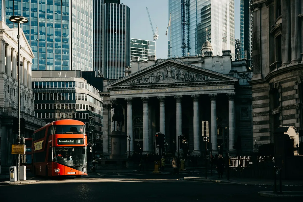 London financial district, Royal Exchange and glass towers with a red bus.