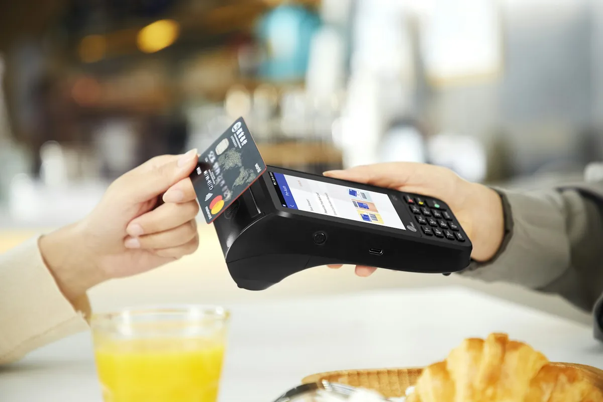 A contactless bank card payment on a black touchscreen payment terminal