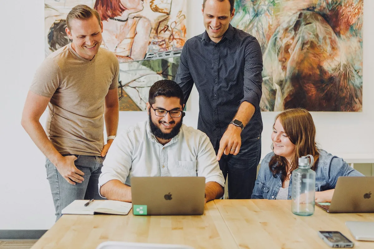 Colleagues working together around laptops in a business workspace