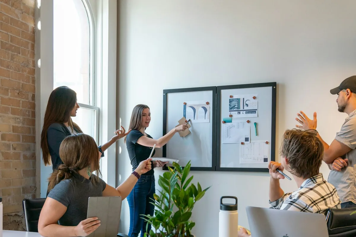 A project workshop with colleagues discussing plans displayed on a board