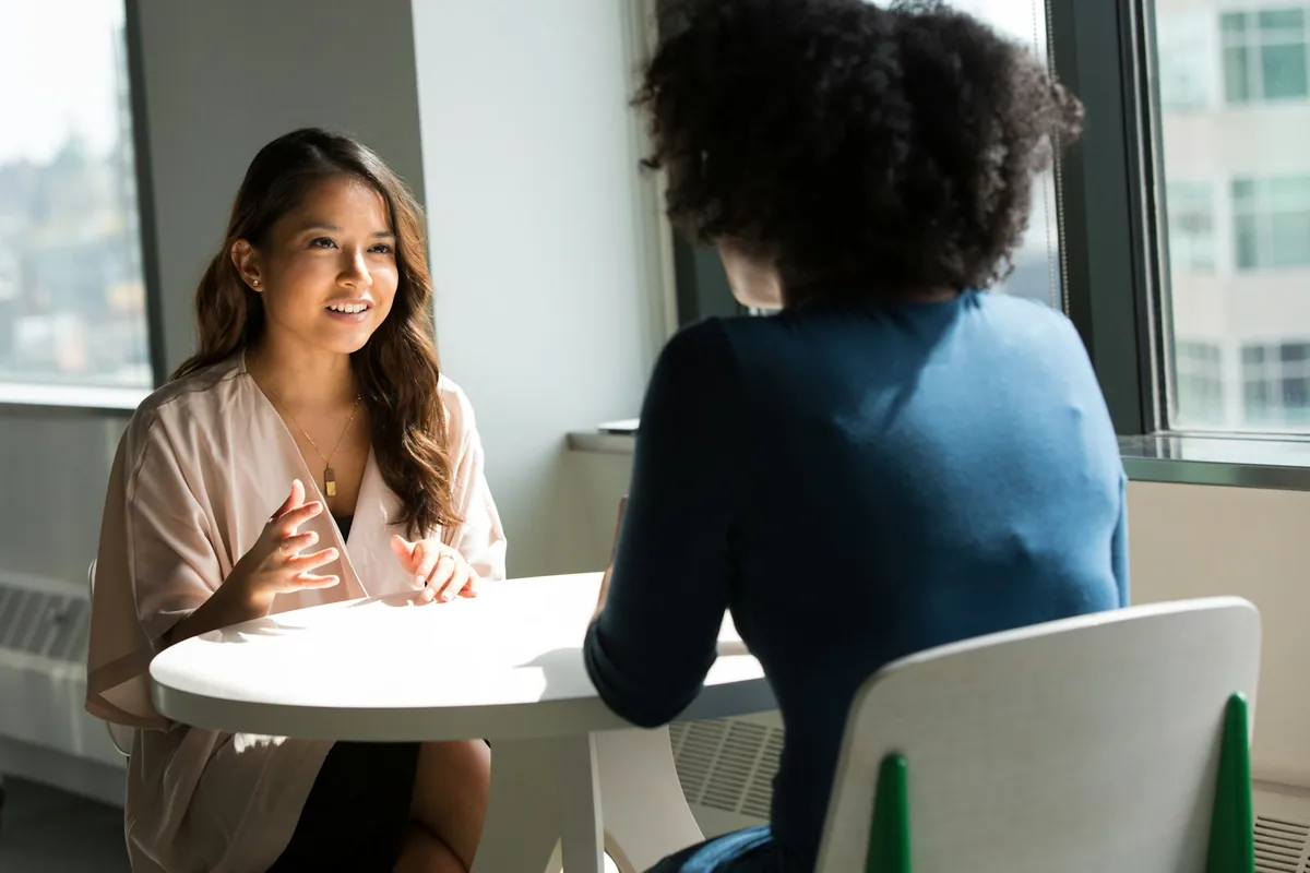 Two colleagues discussing work during a one-to-one coaching conversation