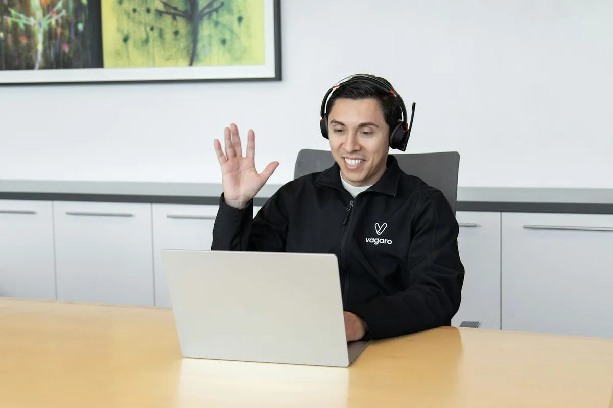 Customer support professional wearing a headset at a laptop